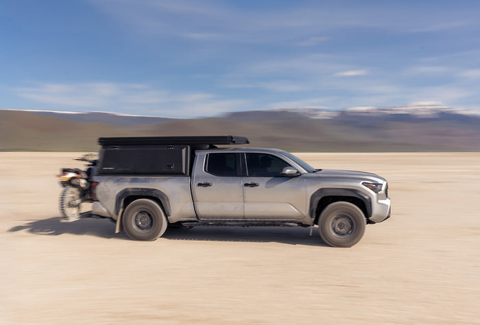 Photo of Super Pacific X1 Camper on a Toyota Tacoma driving through the desert.