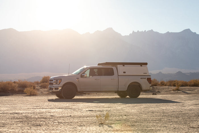 Truck camper parked in the desert at sunset with glowing dust, illustrating protection from heat, dust, and rodents