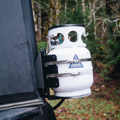 Propane tank attached to the back of a Super Pacific X1 Camper with a forest background