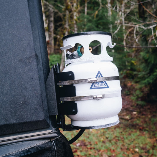 Propane tank attached to the back of a Super Pacific X1 Camper with a forest background