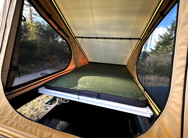 Spacious sleeping area inside Rivian R1T X1 pop-up camper from Super Pacific