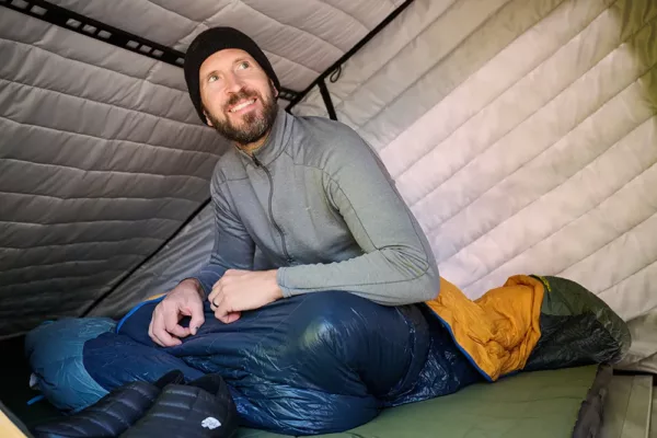 Picture of man in the tent of an X1 Camper with Insulation Kit installed.